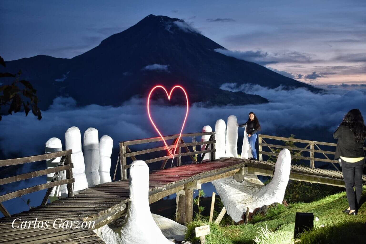 manos de dios mirador en la noche con luces led y puente de madera