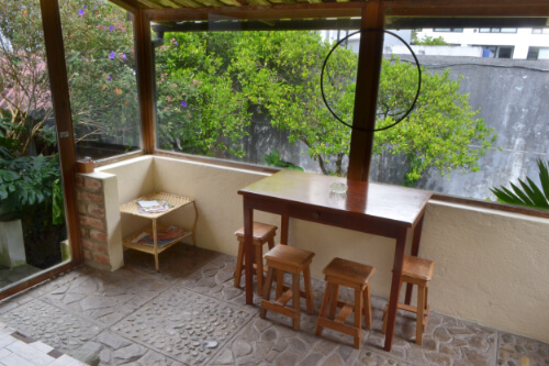 zona de fumadores con juegos de mesa y vista al jardin de casa vacacional